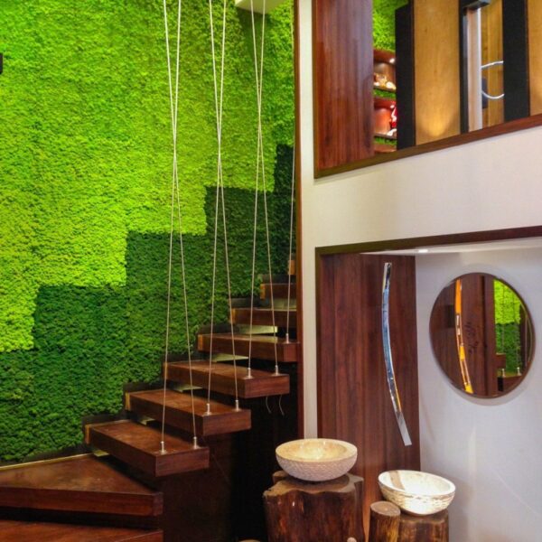 Reference image of Polarmoss Flex Element. Two-toned large green colored moss wall panel beside staircase.